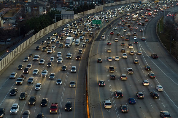 Heavy traffic congestion during rush hour on a major Atlanta highway, with vehicles densely packed in multiple lanes.
